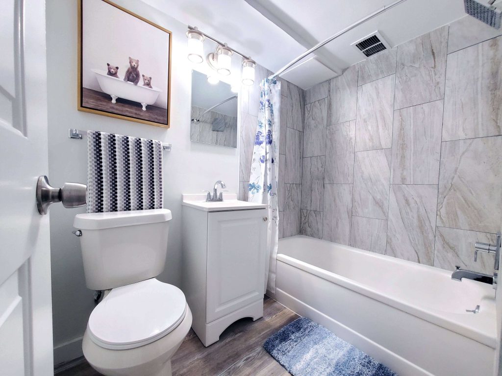 Shorewood Apartments, Cleveland, OH: renovated bathroom with large-tile tub surround and white vanity