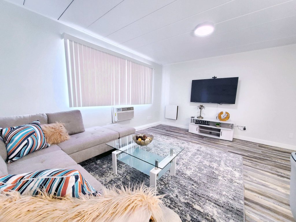 Shorewood Apartments, Cleveland, OH: living room with sectional sofa, glass coffee table and wall-mounted TV